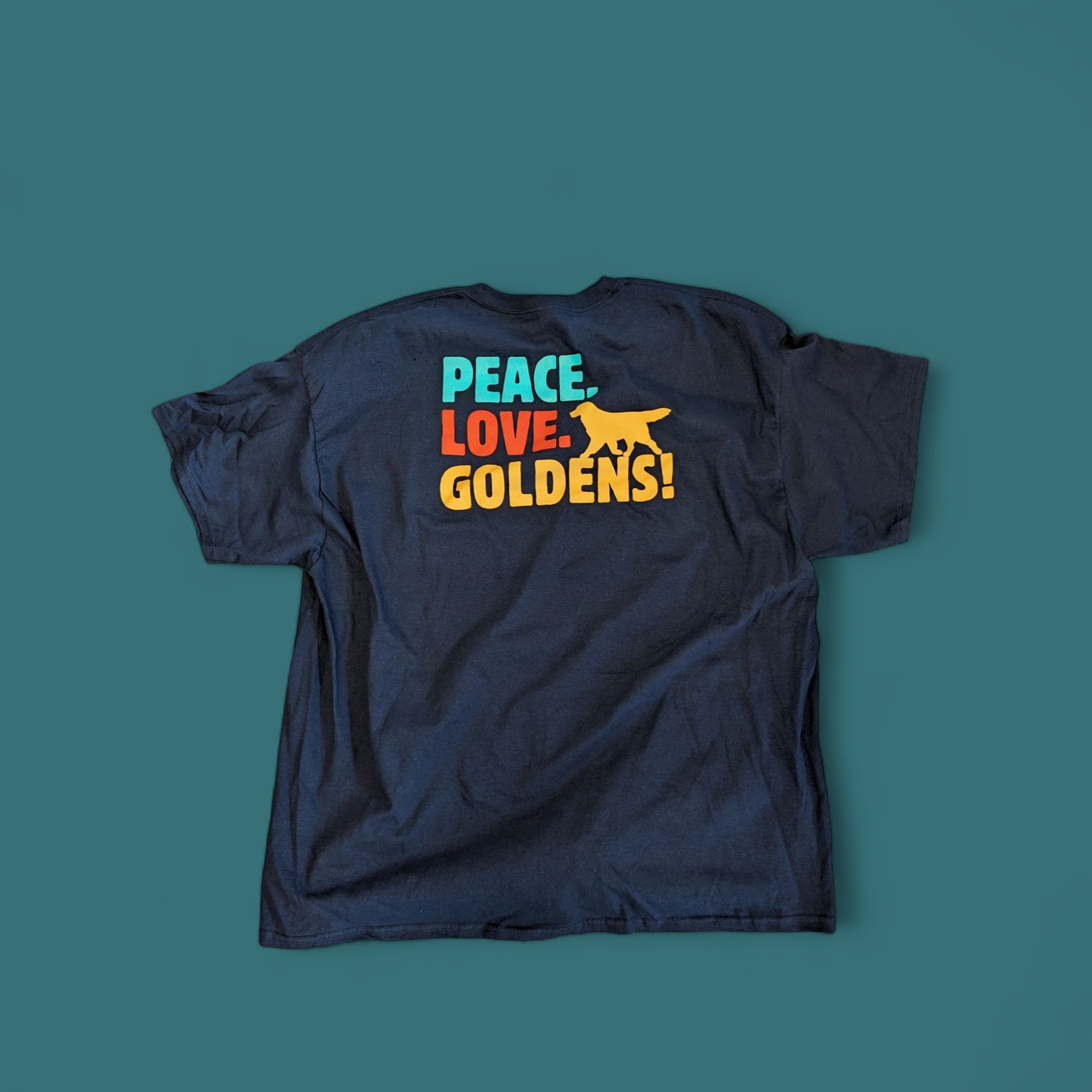 Finished custom screen-printed navy T-shirt with a colorful 'Peace. Love. Goldens!' design and golden retriever graphic, produced by East Coast Embroidery in East Providence, Rhode Island